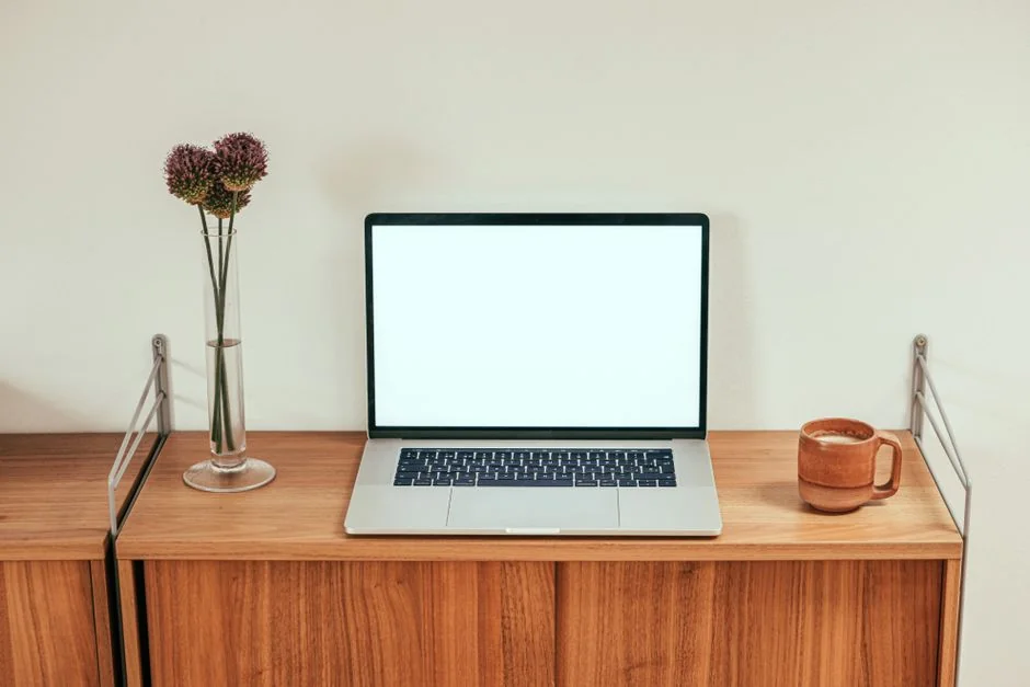Un espace de travail dynamique avec un ordinateur portable, une tablette et une télévision, baigné d’un éclairage coloré.
